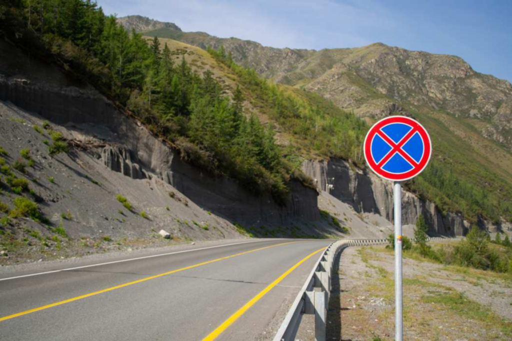 Un cartello stradale che raffigura il divieto di fermata in una strada di montagna