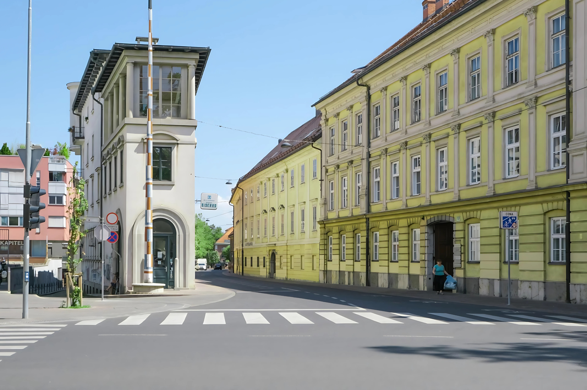 Una strada con in vista delle strisce pedonali e dei palazzi sullo sfondo